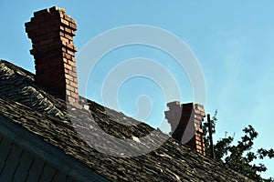 Shot of two chimneys made of stone under the blue sky