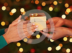 Tis better to give than to receive. Shot of two unrecognizable women exchanging gifts at Christmas.