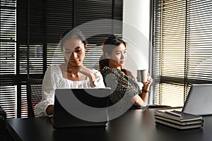 Shot of two young Asian woman worker working together in office.