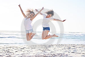 Celebrate your friendship everyday. Shot of two young women jumping for joy at the beach.