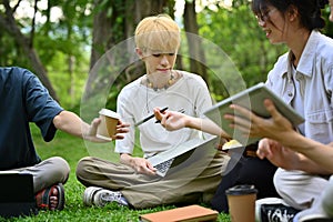 Shot of university students doing group project together in university campus. Education and youth lifestyle concept