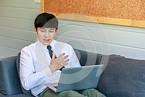 Shot of unrecognizable unknown male businessman employee in formal business outfit sitting on cozy sofa couch with laptop holding