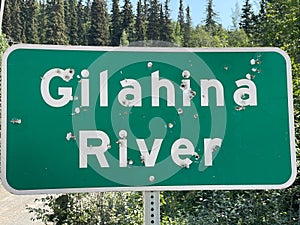 A shot-up sign Gilahina River, The McCarthy Road, Alaska