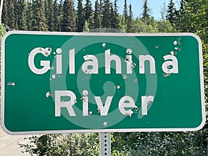 A shot-up sign Gilahina River, The McCarthy Road, Alaska photo