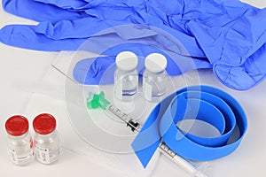 Shot of vaccine containers, a tape, gloves, syringe and other medical products on a table