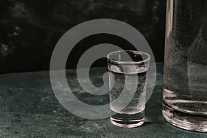 Shot of vodka and bottle on table. Concept of drinking alcohol, drinks in authentic bar