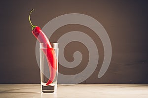 Shot of vodka and red pepper/shot of vodka and red pepper on a dark background. Selective focus and copyspace