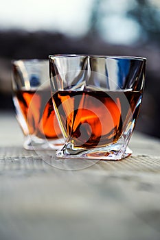 shot of whiskey at sunset dramatic sky on mountain landscape background