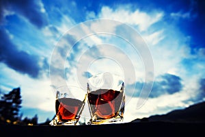 shot of whiskey at sunset dramatic sky on mountain landscape background