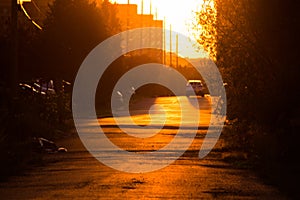 Shot of a white car going down the road during sunset