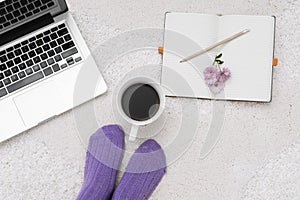Shot of woman feet, laptop, coffee and notebook on the white car