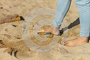 Shot of a woman's barefoot leg playing with sand, Barceloneta beach, Barcelona, Spain