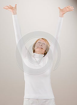 Shot of woman in white reaching with arms raised