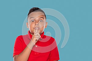 Shot of a young boy  holding forefinger at his mouth and with  asking not to tell a secret