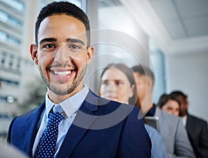 Looking forward to new beginnings. Shot of a young businesswoman standing in line in a modern office.