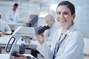 Youll never guess what Ive found. Shot of a young female lab tech using her microscope.