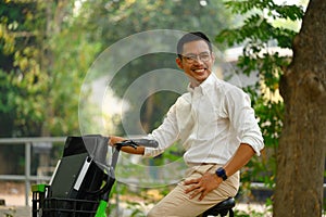 Shot of young handsome businessman riding bicycle to work in morning