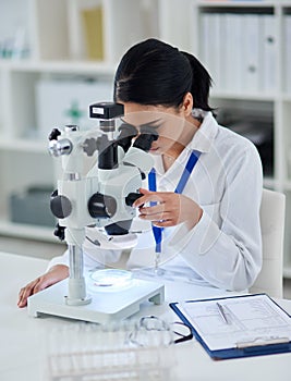 Theres nothing her microscope cant find. Shot of a young scientist using a microscope in a laboratory.