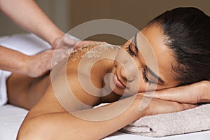 Massaging away all the worries and stress. Shot of a young woman enjoying a back massage at a spa.