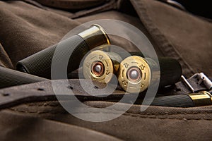 Shotgun shells close-up. Ammunition for smoothbore weapons on a khaki canvas backpack. Dark back