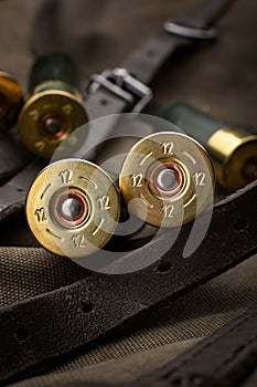 Shotgun shells close-up. Ammunition for smoothbore weapons on a khaki canvas backpack. Dark back