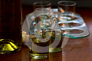 Shots of hard liquor rakija with bottle in the  background photo