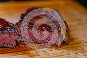 Shots of a sliced fresh rump steak with fat on  the steak on a wooden board