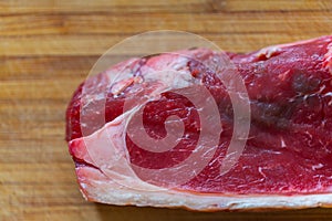 Shots of a sliced raw  fresh rump steak with fat on the steak on a wooden board