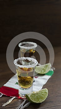 SHOTS OF TEQUILA OVER A VIVA MEXICO HANDKERCHIEF AND A HAT WITH A CIGAR