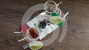 SHOTS OF TEQUILA OVER A VIVA MEXICO HANDKERCHIEF AND A HAT WITH A CIGAR