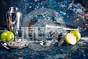 Shots of tequila or strong drink in small glasses, with lime garnish ready to be served