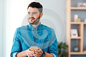 Should I perhaps reword this message. a handsome young man looking thoughtful while using a mobile phone in his living