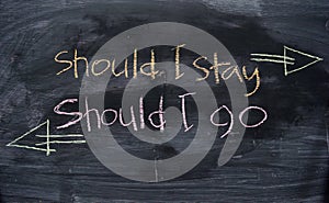 Should I stay or Should I go written with color chalk concept on the blackboard