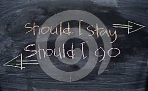Should I stay or Should I go written with color chalk concept on the blackboard photo