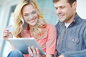 Should we take it. a happy mature couple shopping online using a digital tablet while relaxing together at home.