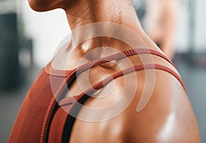 Shoulder, closeup and injury on woman at gym for fitness, training or workout while feeling discomfort. Arm pain, girl