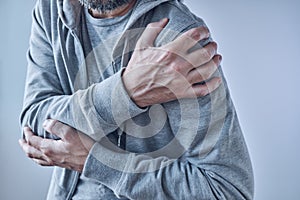 Shoulder joint pain, man with severe ache as symptom of osteoarthritis photo