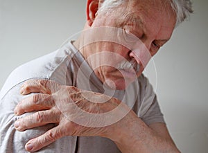 Shoulder joint pain on an older man photo