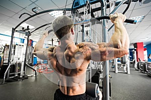 Shoulder pull down machine. Fitness man working out lat pulldown training at gym. Upper body strength exercise for the