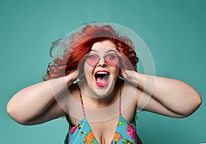 Shouting laughing loud overweight fat woman holds her head with hands can`t believe huge discount sale or crazy luck photo