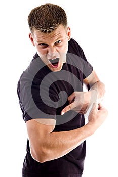 Shouting man pointing at his muscles