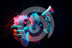 Shouting with megaphone. Young woman with smoke and neon light on black background. Highly tensioned, wide angle, fish