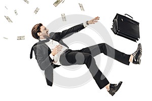 shouting young businessman falling with money and briefcase