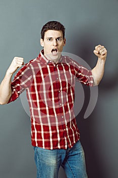 Shouting young man with arms raised expressing his exasperation