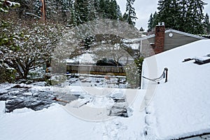 Shovel and fresh wet snow on a flat carport roof, no people, residential neighborhood