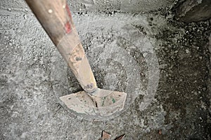 Shovel in front of the recently made plastered wall by concrete