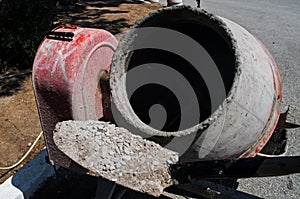 Shovel with grit and cement mixer machine.