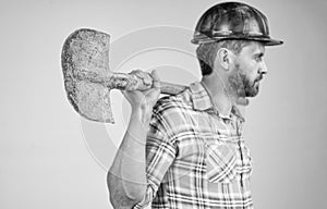 shovel in hand of man laborer. guy wear worker uniform. handsome builder in helmet.