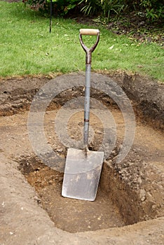 Shovel in hole for pond