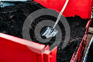 Shovel in a pile of peat soil.